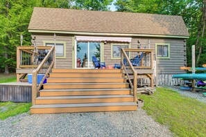 A cabin with a wooden staircase leading to a deck, surrounded by trees. - Paddle, Fish & Stargaze: Peaceful Lincoln Escape (Lincoln)