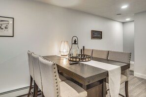 A dining area with a wooden table, cushioned chairs, a candle centerpiece, and a framed quote on the wall. - Beautiful West Harwich Home: 1 Mile to Beach! (Harwich)