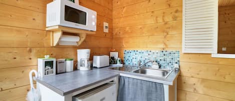 A compact kitchen with a microwave, toaster, and sink.