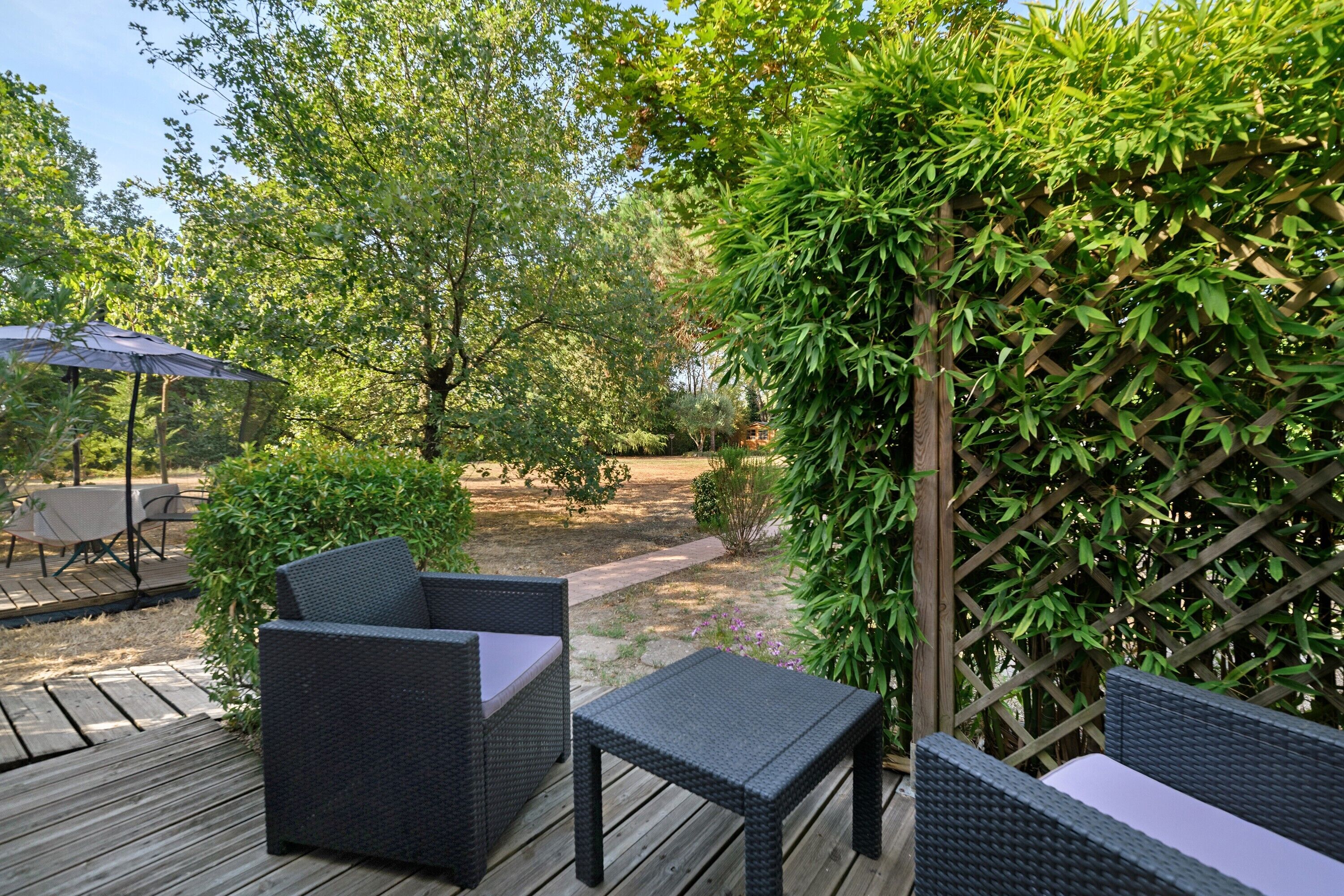 Eine Terrasse im Freien mit Korbmöbeln und einer Holzterrasse.