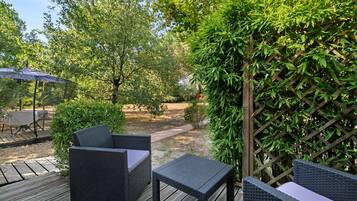 Eine Terrasse im Freien mit Korbmöbeln und einer Holzterrasse.