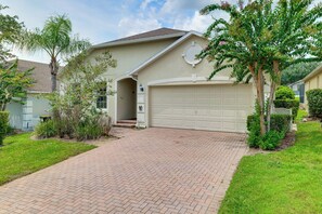 A residential house with a brick driveway, a garage, and a well-maintained lawn. - Heated Pool & Game Room! Family Hub 9 Mi to Disney (Davenport)
