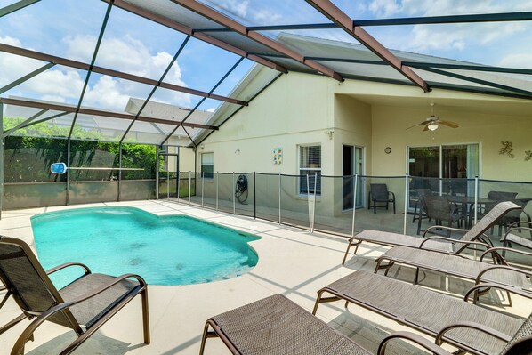 Une piscine extérieure avec des chaises longues et un patio couvert.