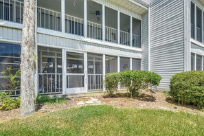 A two-story building with a balcony, a covered porch, and a small garden area with shrubs. - Boat Dock, Slips & Pool! St Johns River Condo (Welaka)