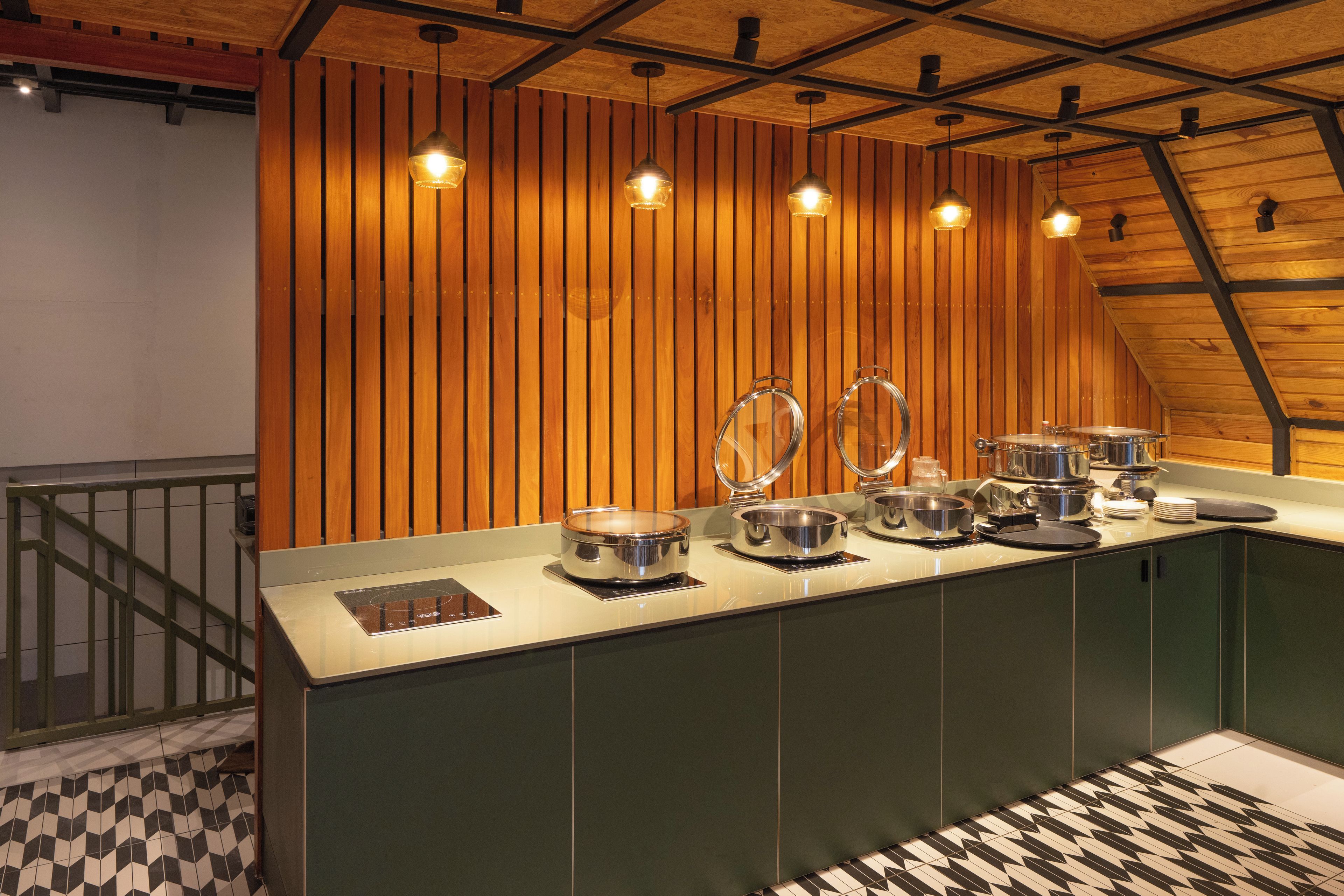 A kitchen with wooden paneling, pendant lighting, and stainless steel appliances.