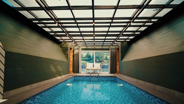 Piscina interior con vistas a zonas verdes.