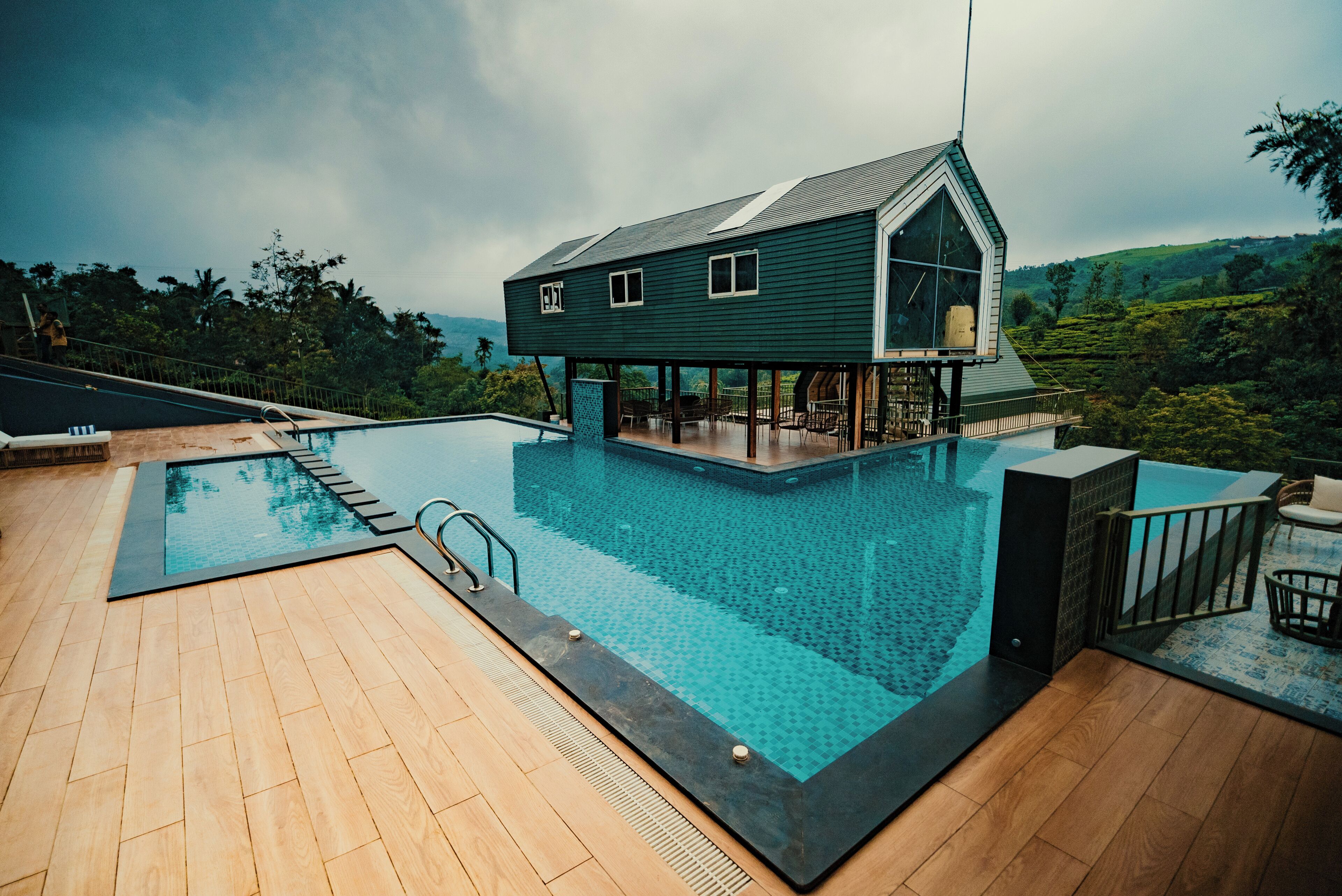 A modern house with a pool, surrounded by lush greenery.