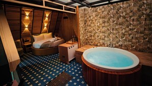 Un baño moderno con una bañera grande, un banco de madera y un revestimiento de pared con diseño.