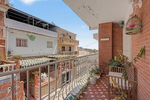 A residential balcony with a tiled floor, potted plants, and a metal railing. - Apartment 'El Olivo 2' with 2 Private Terraces, Wi-Fi, and Air Conditioning (Málaga)