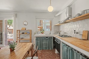 A kitchen with a wooden countertop, a stove, and a sink. - Apartment 'El Olivo 2' with 2 Private Terraces, Wi-Fi, and Air Conditioning (Málaga)