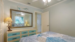 A bedroom with a bed, dresser, mirror, and ceiling fan. - Flip-Flop to Beach & Flagler Ave! Breezy Getaway (New Smyrna Beach)