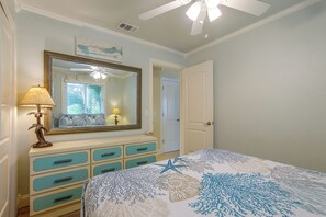 A bedroom with a bed, dresser, mirror, and ceiling fan. - Flip-Flop to Beach & Flagler Ave! Breezy Getaway (New Smyrna Beach)