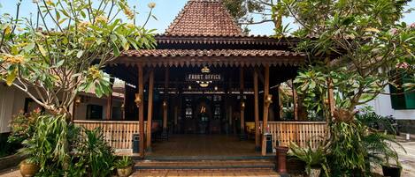 A traditional building with a tiled roof, a sign reading 'FRONT OFFICE,' and a covered entrance with steps leading up to it.