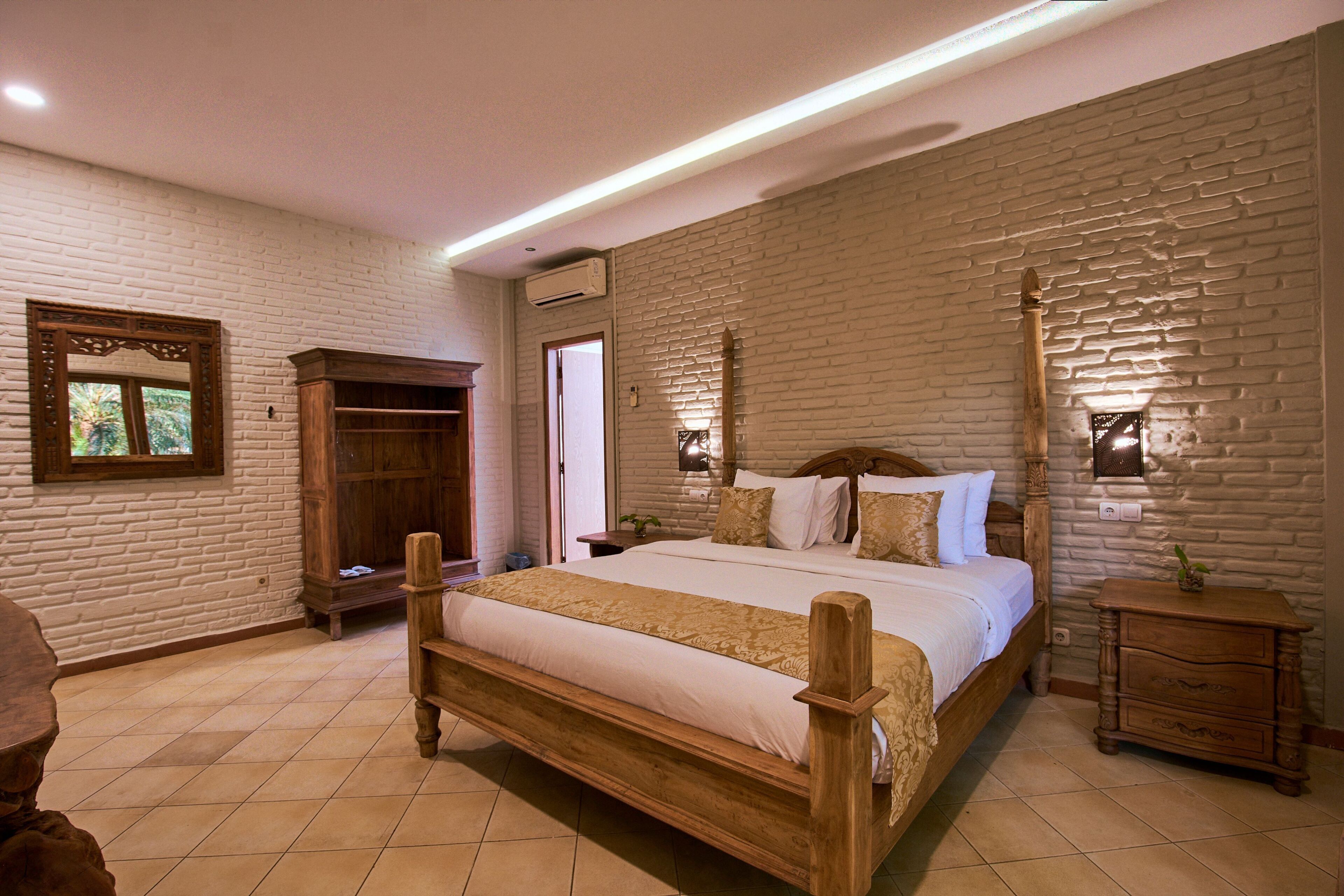A bedroom with a large bed, wooden headboard, a wardrobe, and a nightstand.