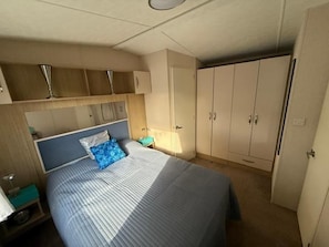 Un dormitorio con cama, armario y mesita de noche.