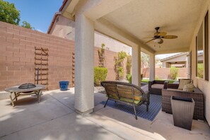 A covered patio area with outdoor furniture, a ceiling fan, and a brick wall. - Spacious Vegas Retreat < 10 Mi to the Strip! (Las Vegas)