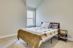 Une chambre à coucher avec un lit, une fenêtre et une table de chevet.