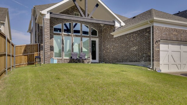 A residential house with a brick exterior, large windows, and a garage. - Spacious Rowlett Home | Ideal for Extended Stays (Rowlett)