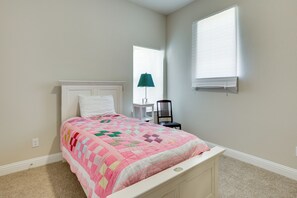 A bedroom with a bed, a chair, a window, and a lamp. - Spacious Rowlett Home | Ideal for Extended Stays (Rowlett)