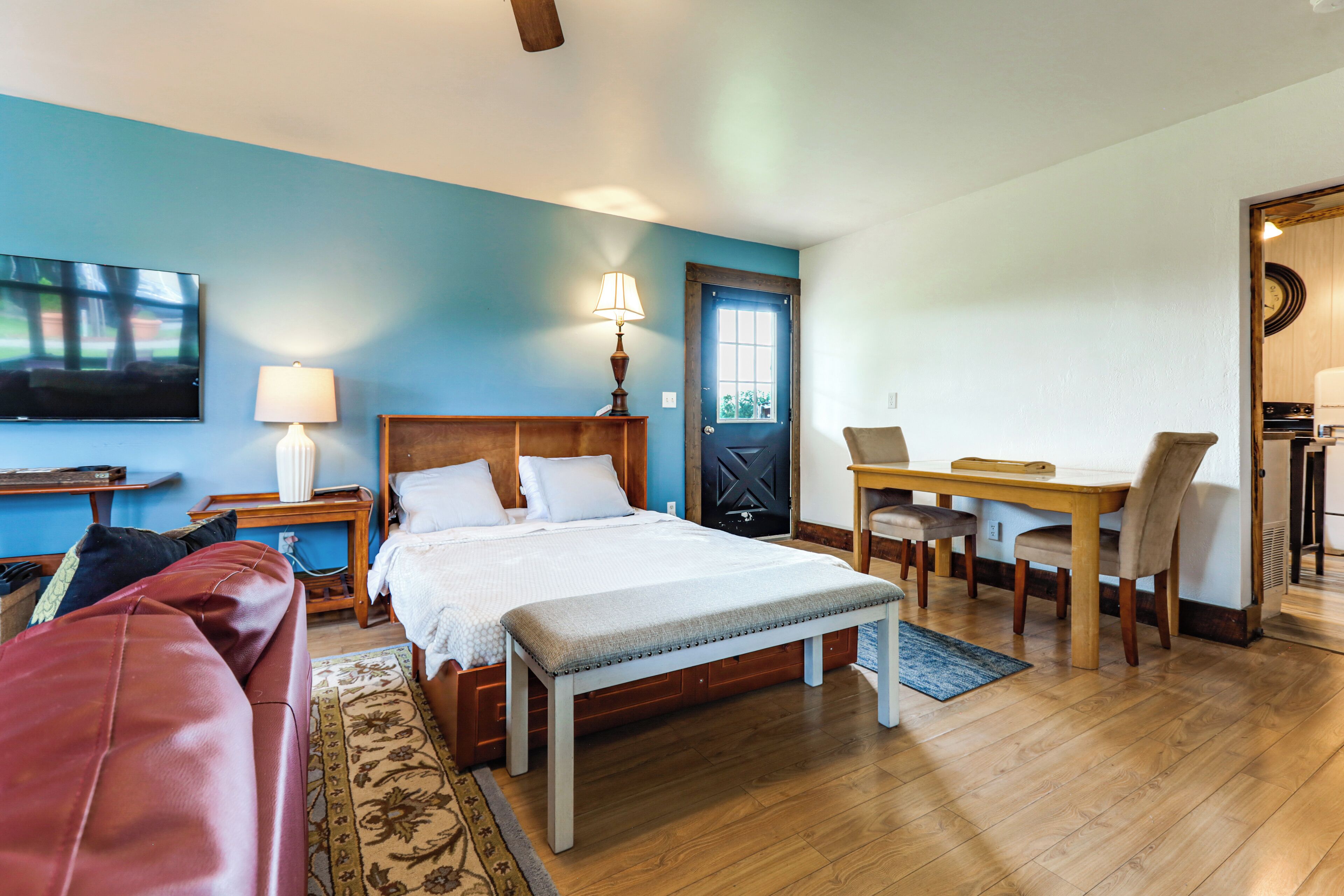 A bedroom with a bed, bedside tables, a desk, and a chair.