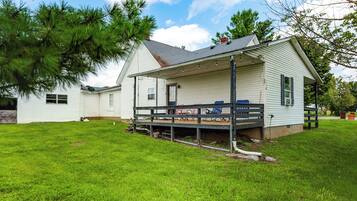 A single-story house with a covered porch and a small deck.