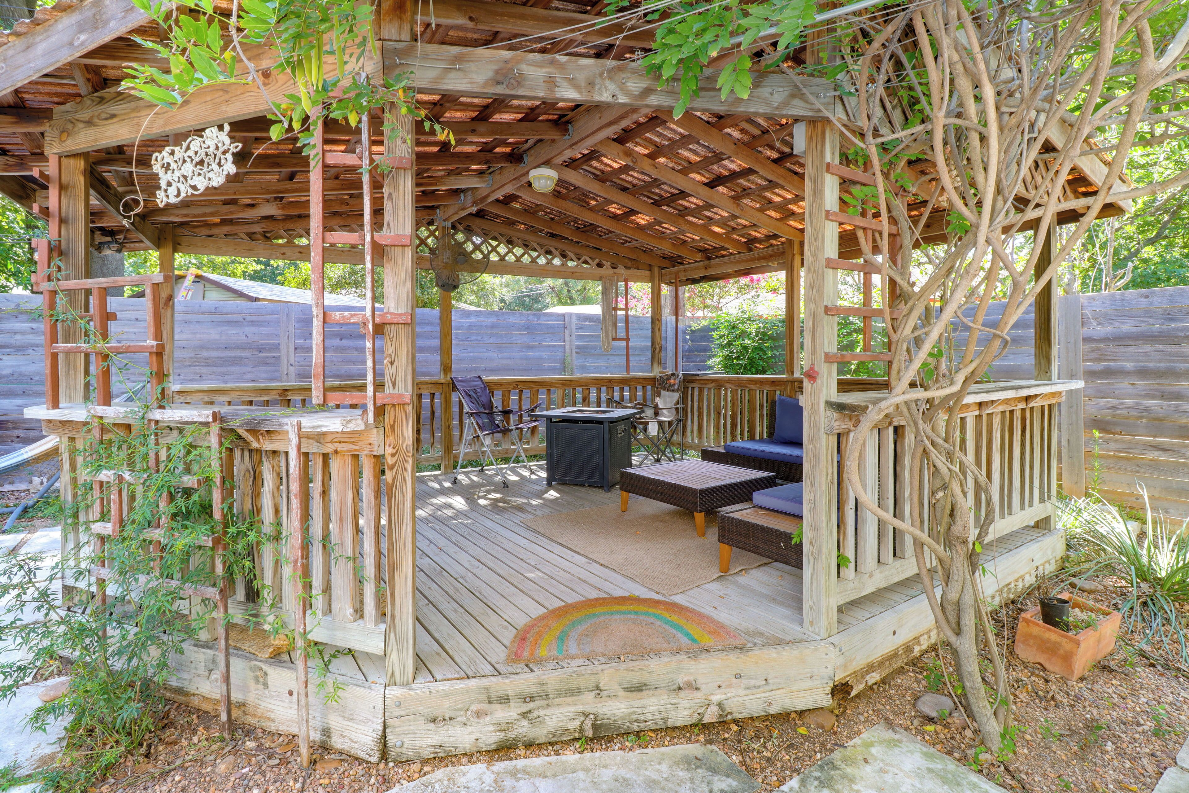 A wooden deck with a covered seating area, including a table and chairs.