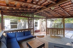 A covered outdoor seating area with a sofa and a table. - Mid-Term Stay in Austin! Family Home w/ Backyard (Austin)