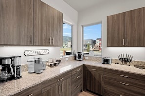 A modern kitchen with wooden cabinets, a coffee bar area, and a view of the outdoors. - 3 King Beds | 3 Baths | 2-Car Garage (Poncha Springs)