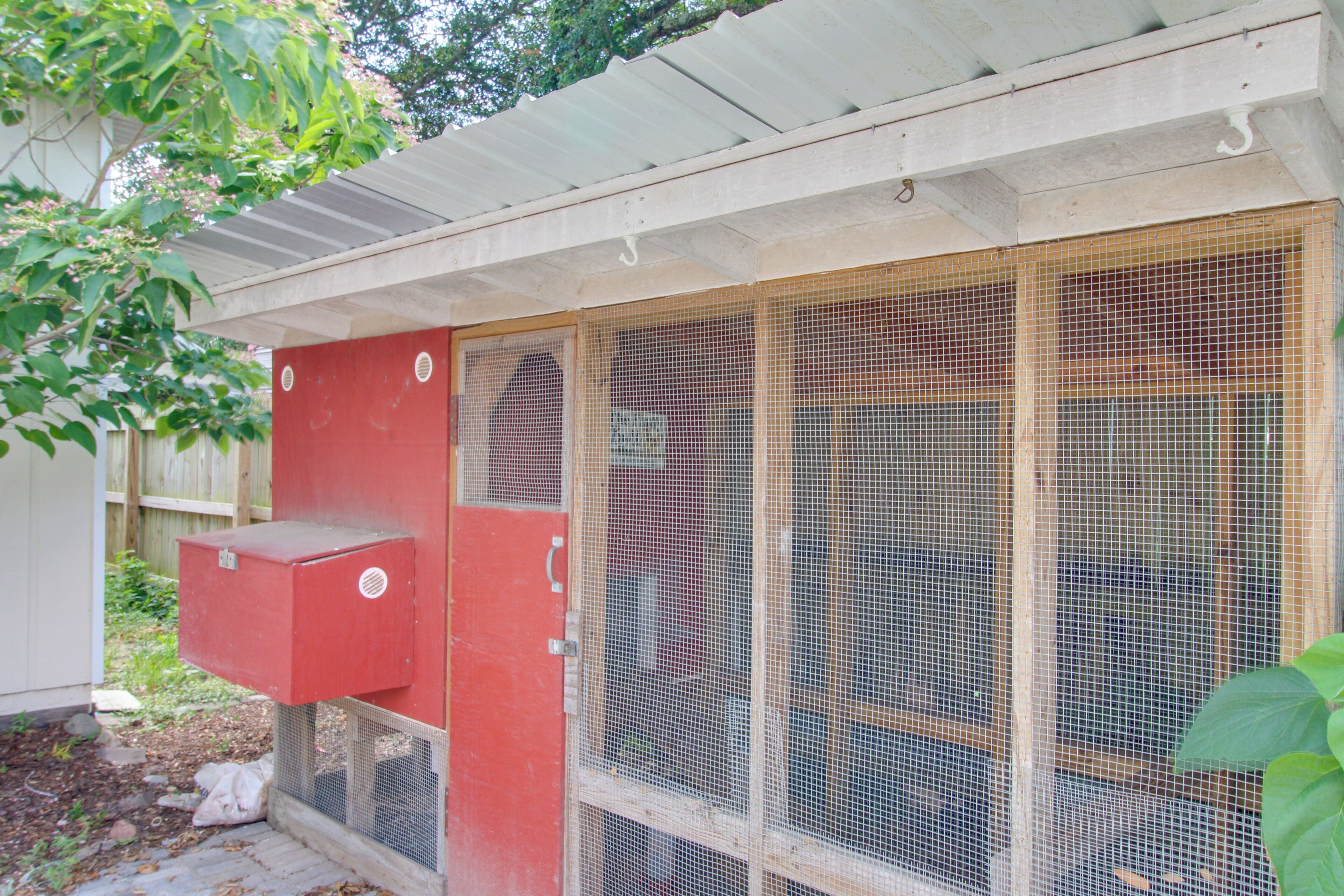 Une boîte de raccordement rouge est fixée à un bâtiment blanc doté d’un toit en métal.