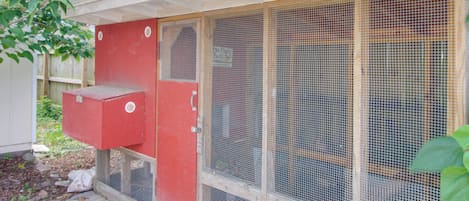 Une boîte de raccordement rouge est fixée à un bâtiment blanc doté d’un toit en métal.