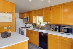 A kitchen with wooden cabinets, a refrigerator, a stove, a microwave, and a dishwasher. - 3 Mi to Sandy Shores & More! Fort Walton Beach Apt (Fort Walton Beach)
