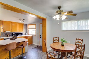 Eine moderne Küche mit Holzausstattung, einer Mikrowelle und einem Essbereich mit Holztisch und -stühlen.
