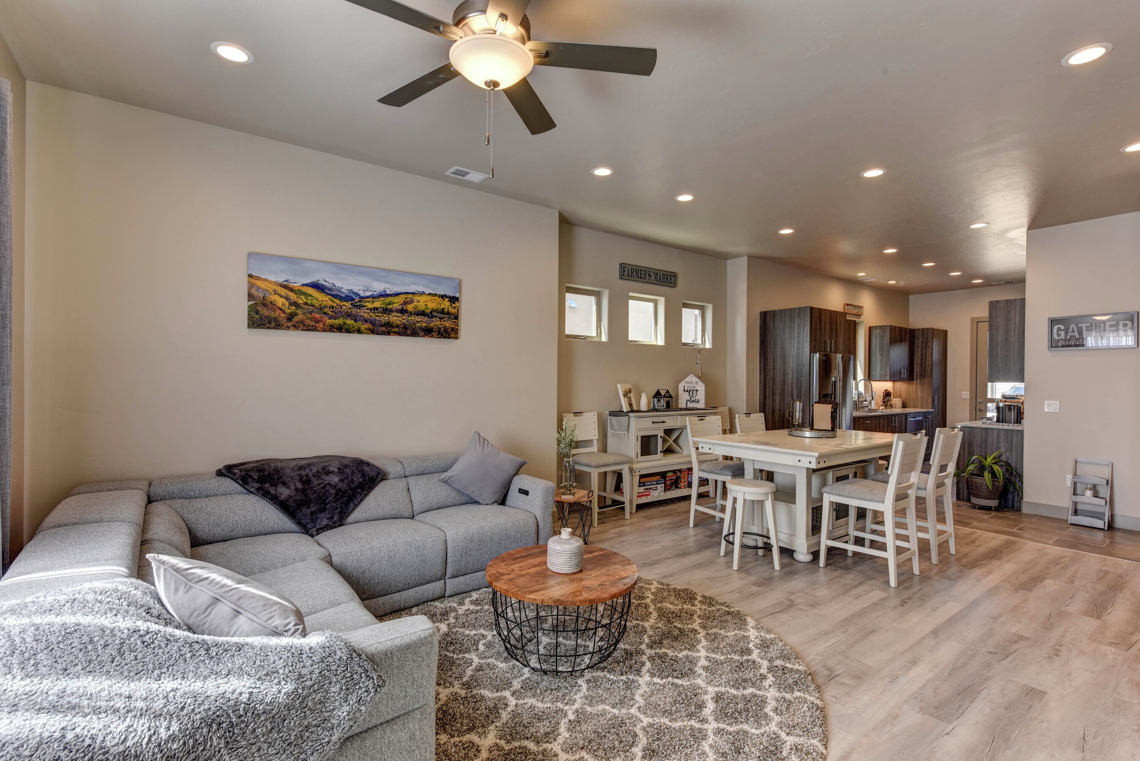 A modern living room with a sectional sofa, a coffee table, and a painting on the wall.