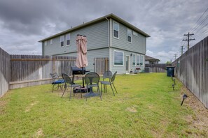 A two-story house with a backyard patio area featuring a table and chairs, a grill, and a covered umbrella. - Fenced Yard! Family Getaway, Near Texas Ski Ranch (San Marcos)