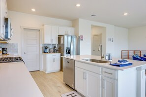 A modern kitchen with white cabinetry, stainless steel appliances, and a built-in dishwasher. - Fenced Yard! Family Getaway, Near Texas Ski Ranch (San Marcos)