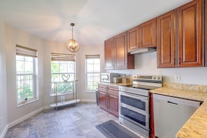 A kitchen with wooden cabinets, a stainless steel range, and a marble countertop. - Extended Stays Welcome! Waterfront Gem in Orlando (Orlando)