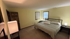 A bedroom with a bed, bedside tables, a lamp, a door, and a window. - Cozy 1-bedroom In-law apartment in cool Middletown with AC (Middletown)