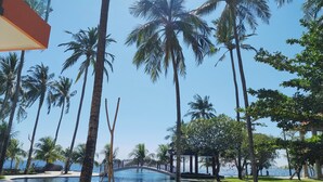 Un resort con piscina, palmeras y un puente.