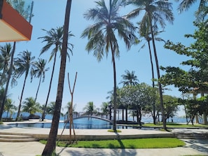 Un resort con piscina, palmeras y un puente.