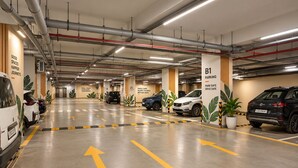 A parking garage with multiple levels, marked parking bays, and directional arrows on the floor.