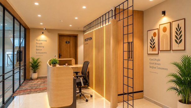 A reception area with a wooden desk, black office chair, and a potted plant.