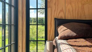 A room with a bed, a window, and a door leading outside. - Beach house with sea view in Røsnæs (Kalundborg)