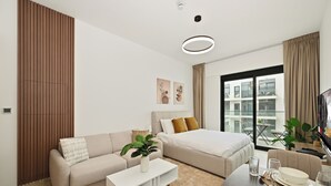 Ein modernes Hotelzimmer mit Sofa, Bett, Couchtisch und Essbereich.