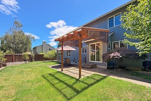 A backyard with a wooden pergola, a patio table, and chairs. - Peaceful 5-Bed Home at Road's End by Woods & Berry Farm, near Parks & Intel/Nike (Hillsboro)