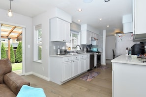A modern kitchen with white cabinetry, a built-in oven, and a microwave. - Peaceful 5-Bed Home at Road's End by Woods & Berry Farm, near Parks & Intel/Nike (Hillsboro)