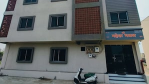 Un edificio de varios pisos con fachada plana, múltiples ventanas y un cartel.