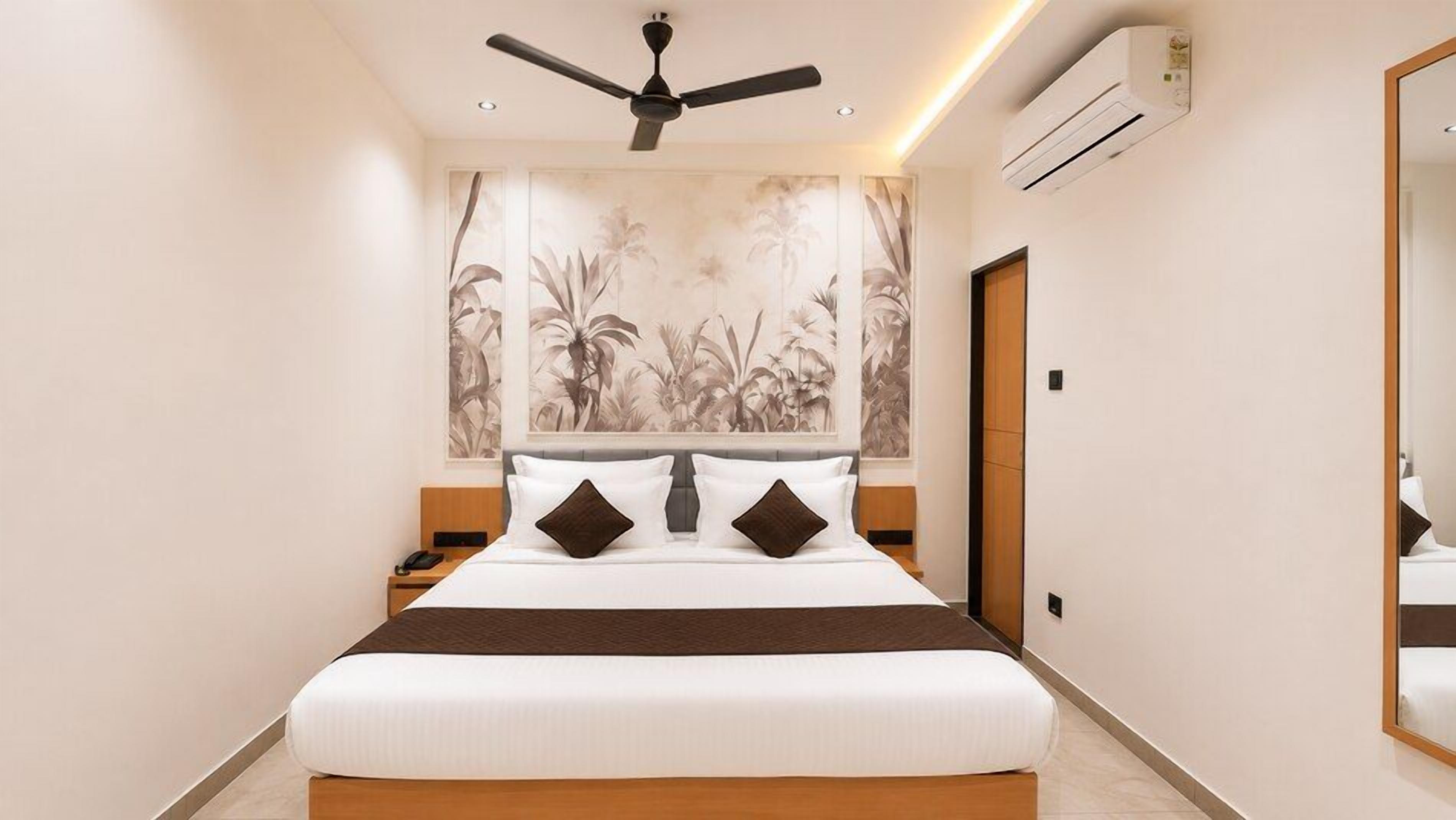 A modern bedroom with a large bed, a ceiling fan, an air conditioning unit, and a large wall mural.