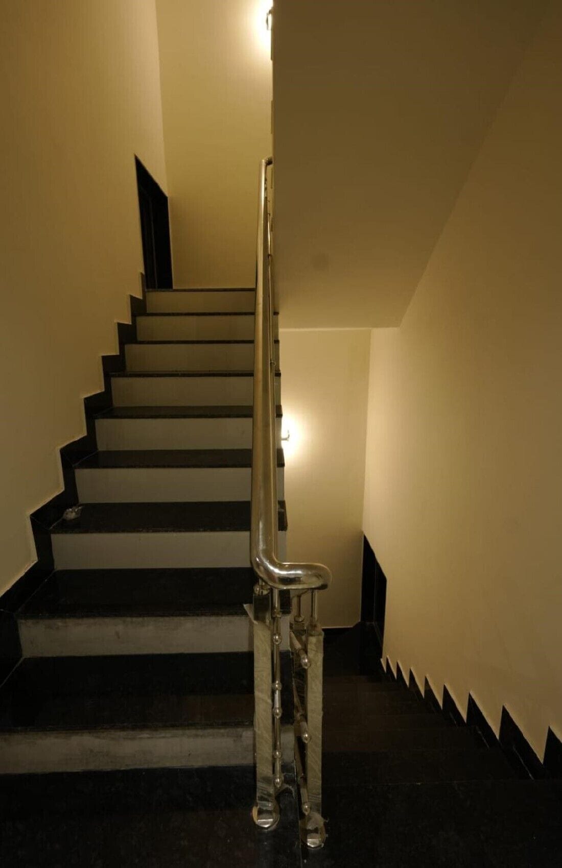 A staircase with a handrail and a light fixture at the top.