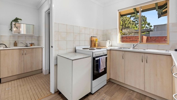 Una cocina moderna con horno integrado, un lavamanos y una ventana con vistas al exterior.
