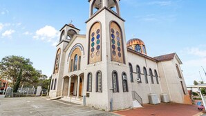 Una iglesia con campanario, ventanas de arco y una cúpula.